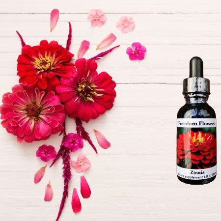 A stock strength bottle of Zinnia Flower Essence with a label showing a vibrant image of red flowers, alongside a small dropper for dispensing.